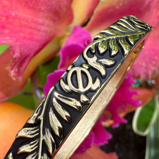 Decorative Bracelet with leaf pattern against a pink flower background