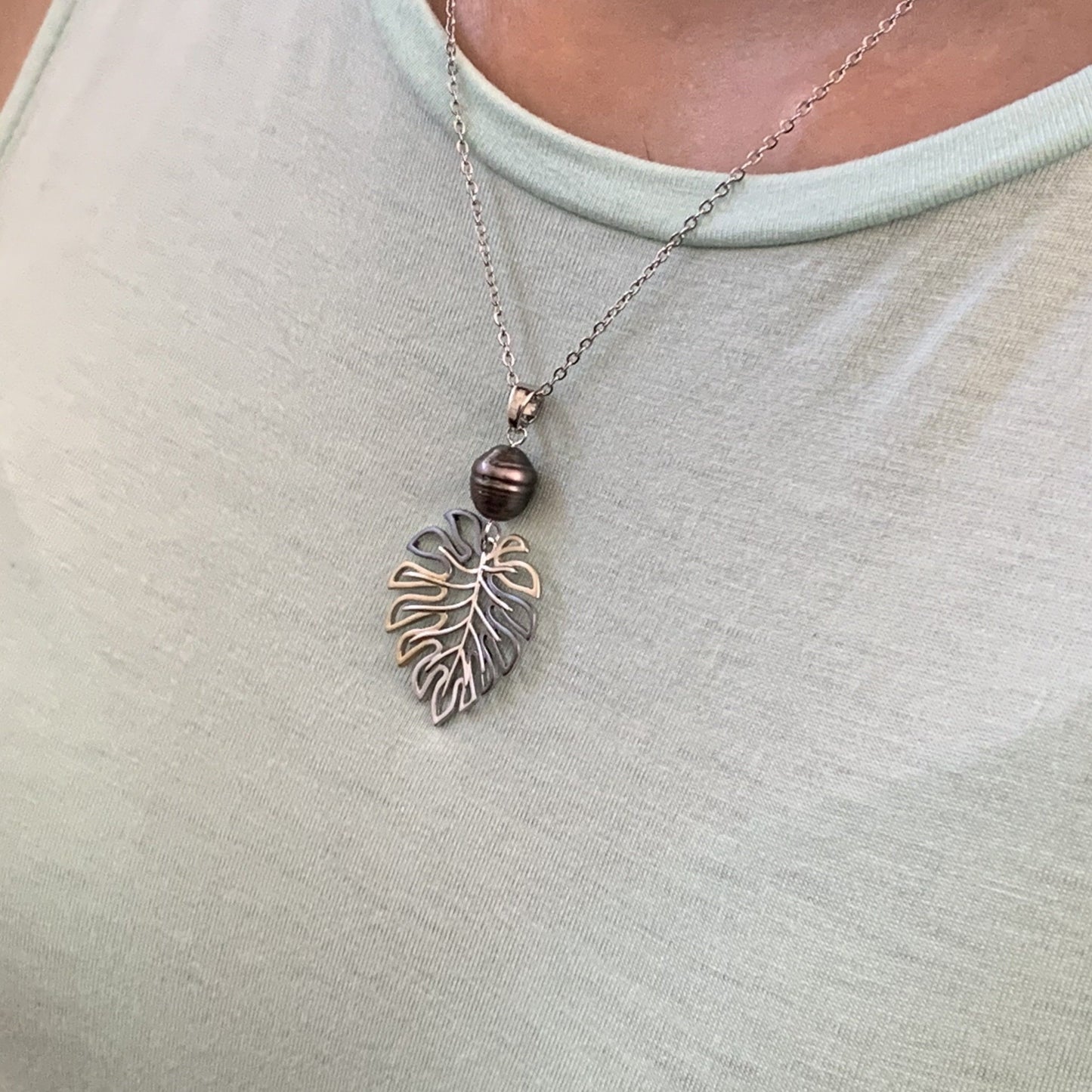 Monstera pearl pendant in black pearl shown on model.