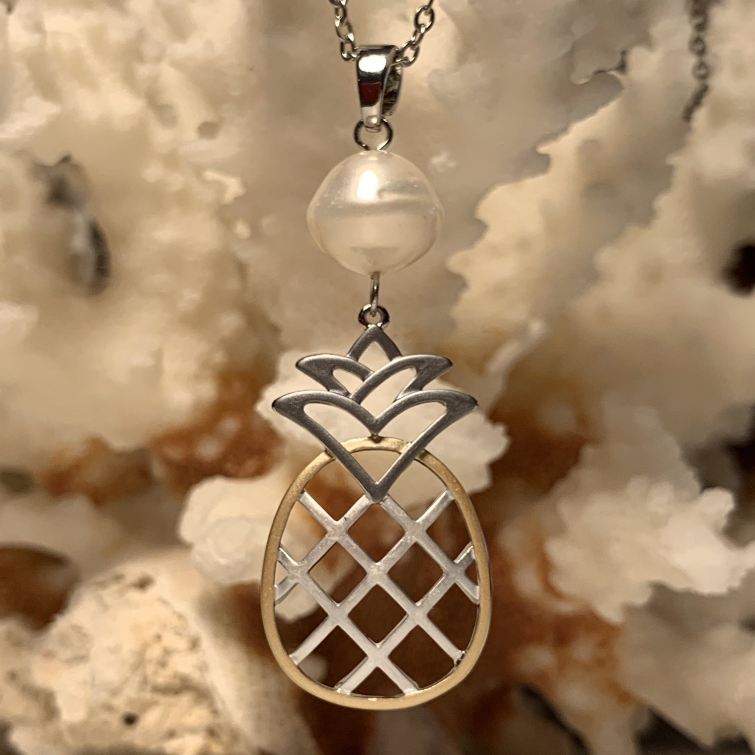 Close up  of white pineapple pearl tri color earrings shown on by itself.