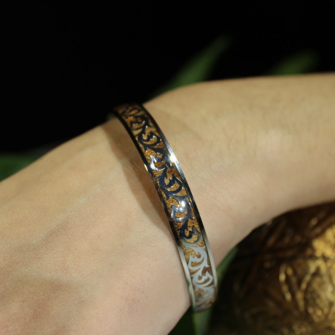 Koa Scroll Fish Hook Stainless Steel Bangle closeup on model