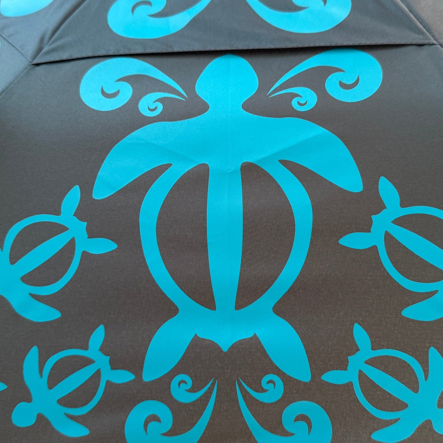 Umbrella with blue turtle pattern on a green background