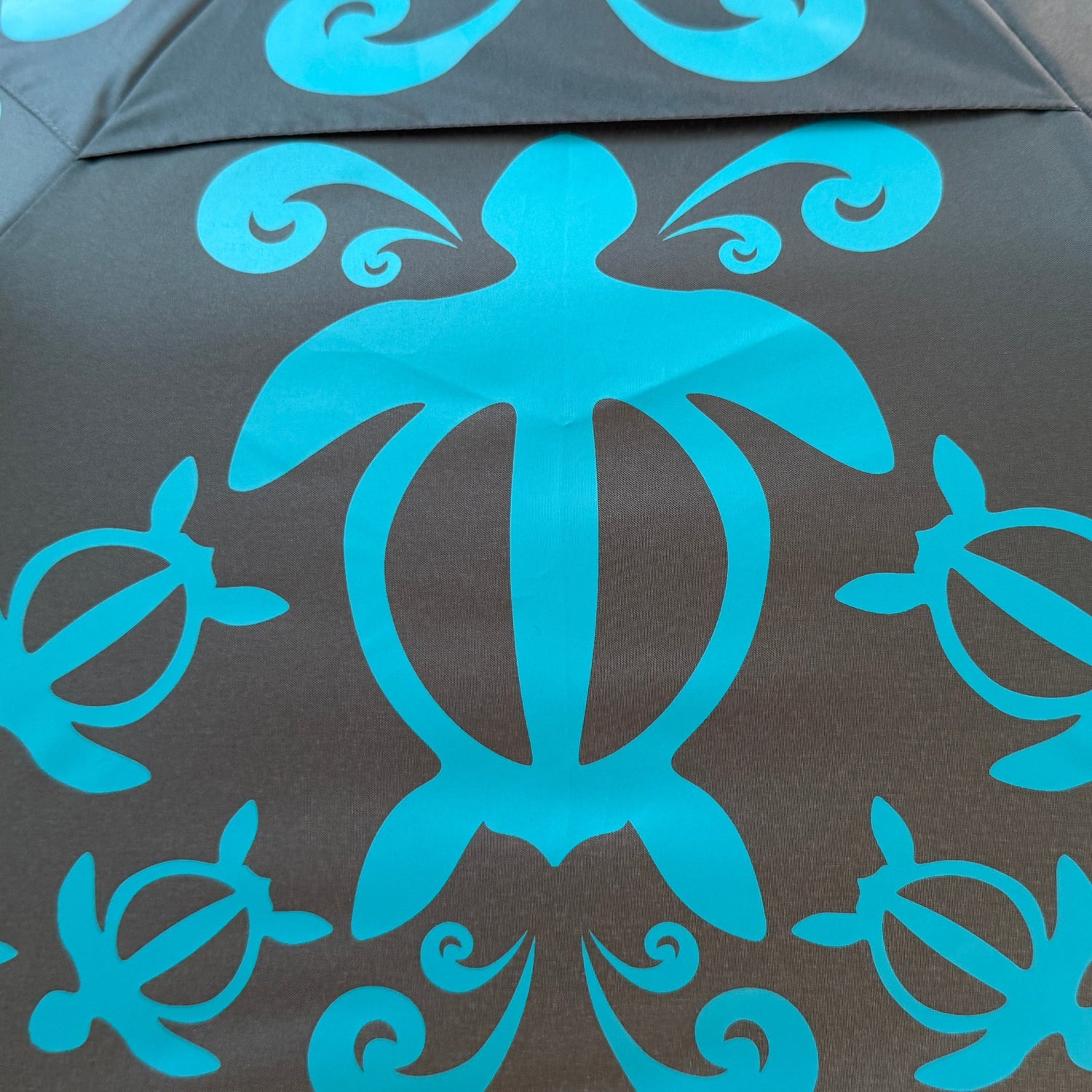 Umbrella with blue turtle pattern on a green background