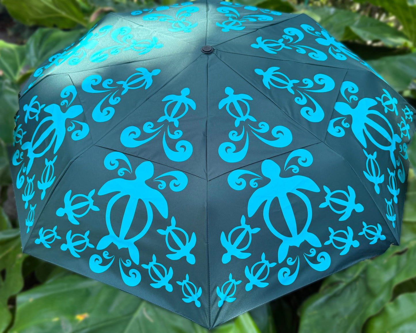 Green umbrella with tealturtle patterns held against a green background