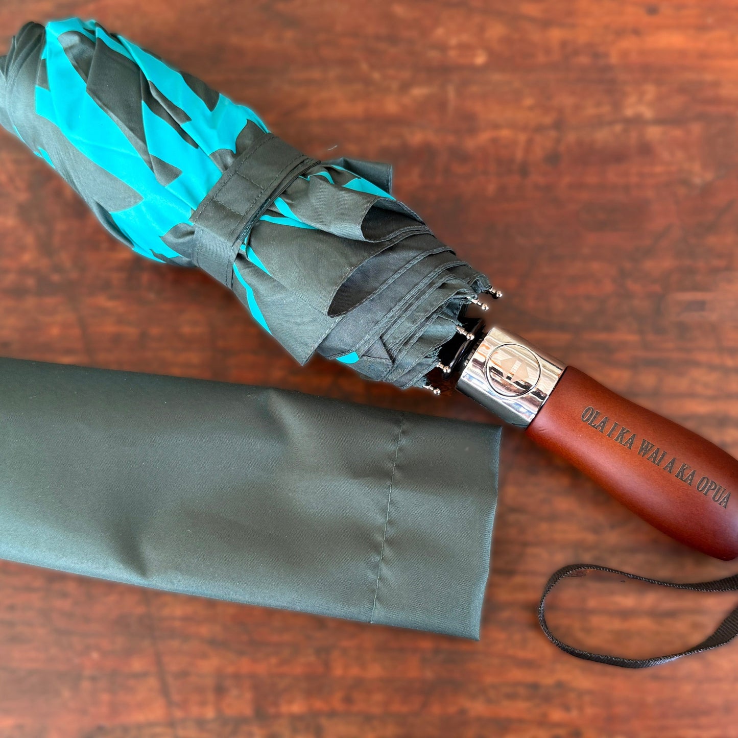 Folded umbrella with wooden handle on a wooden surface