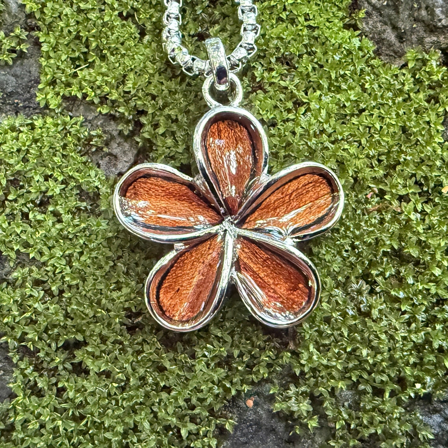 Floral pendant necklace on a mossy stone background