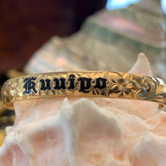 Baby Hawaiian heirloom bracelet with straight edge and black lettering.
