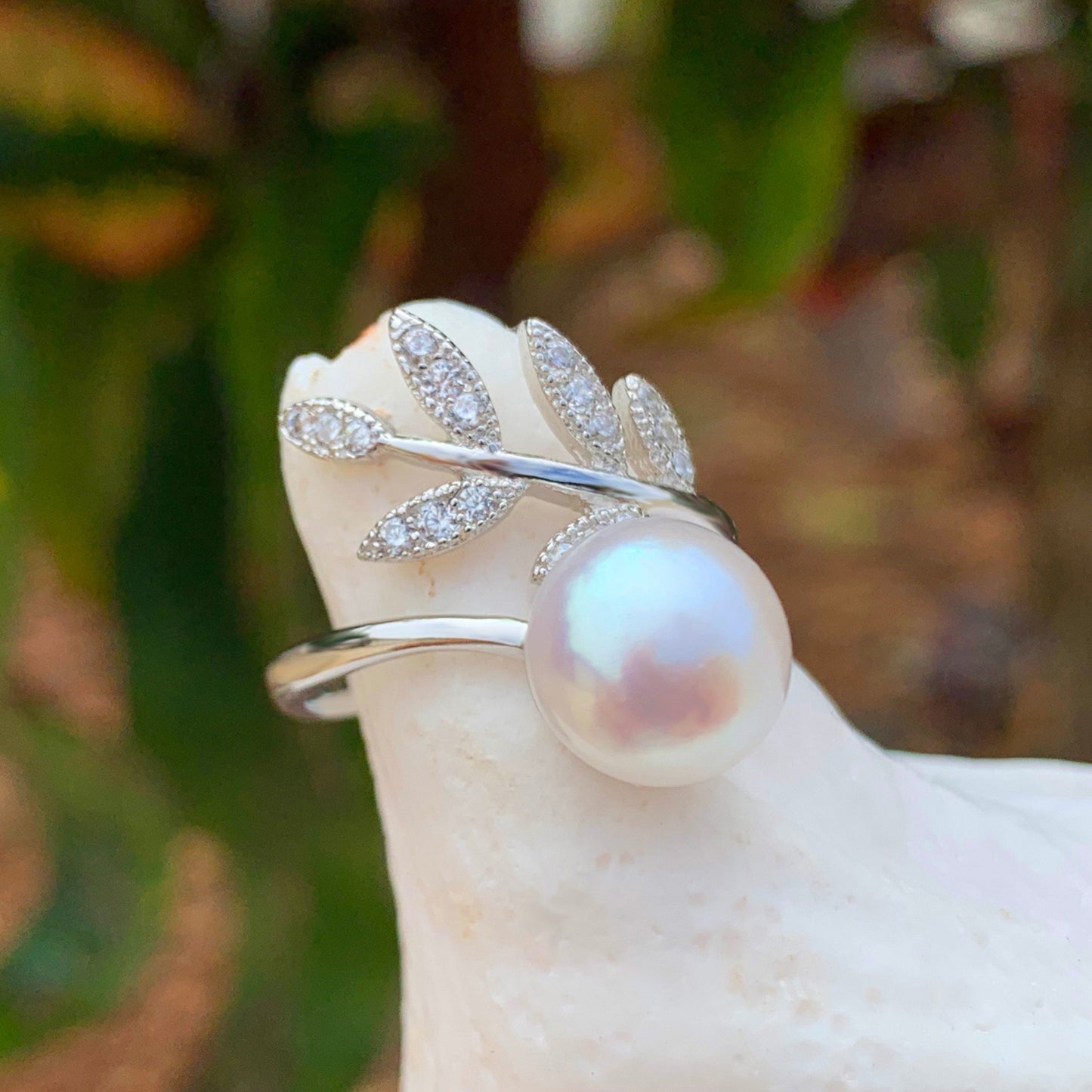 Close up of adjustable Maile Cubic zirconia ring with white pearl made with sterling silver.