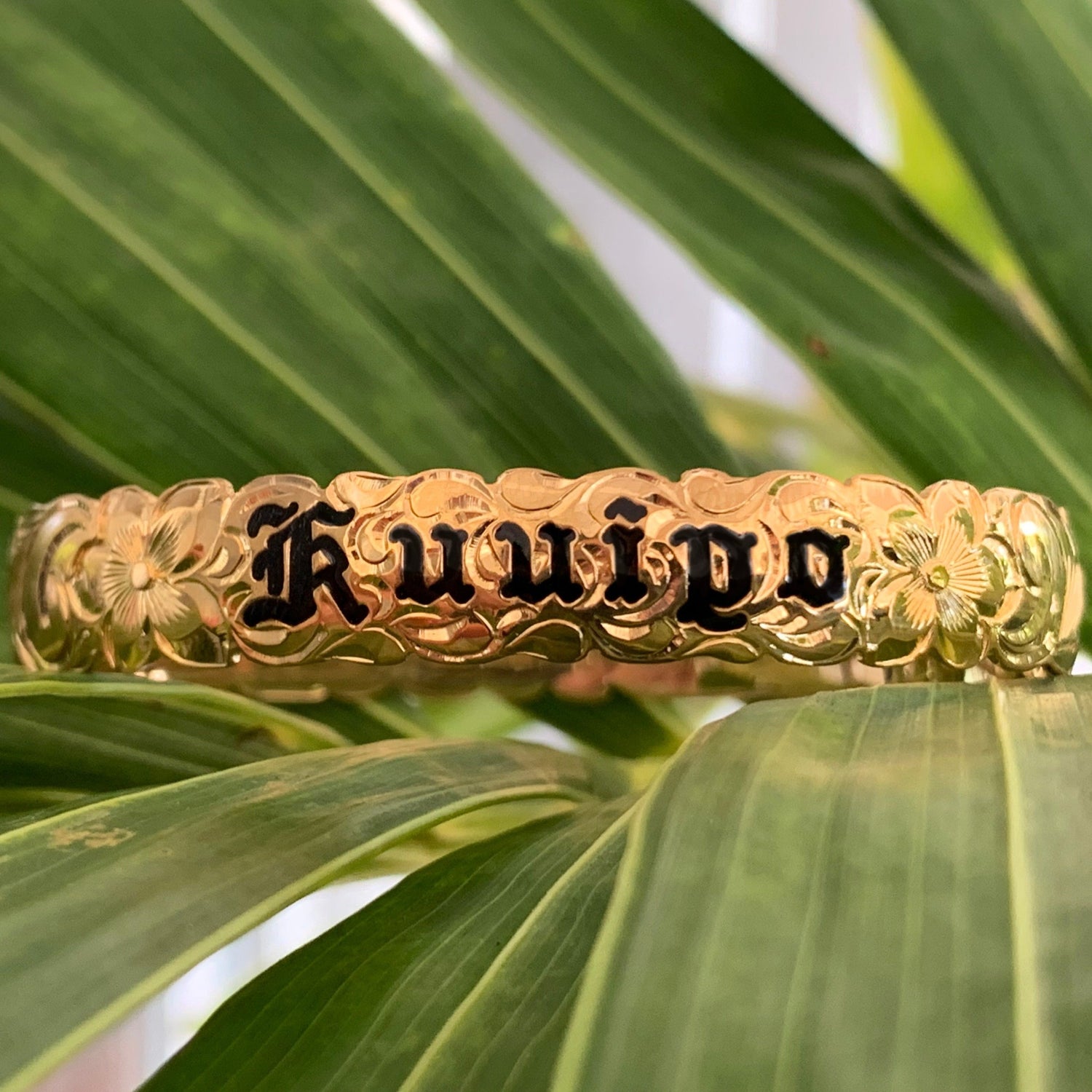 Baby Hawaiian heirloom bracelet with scroll edge and black lettering.