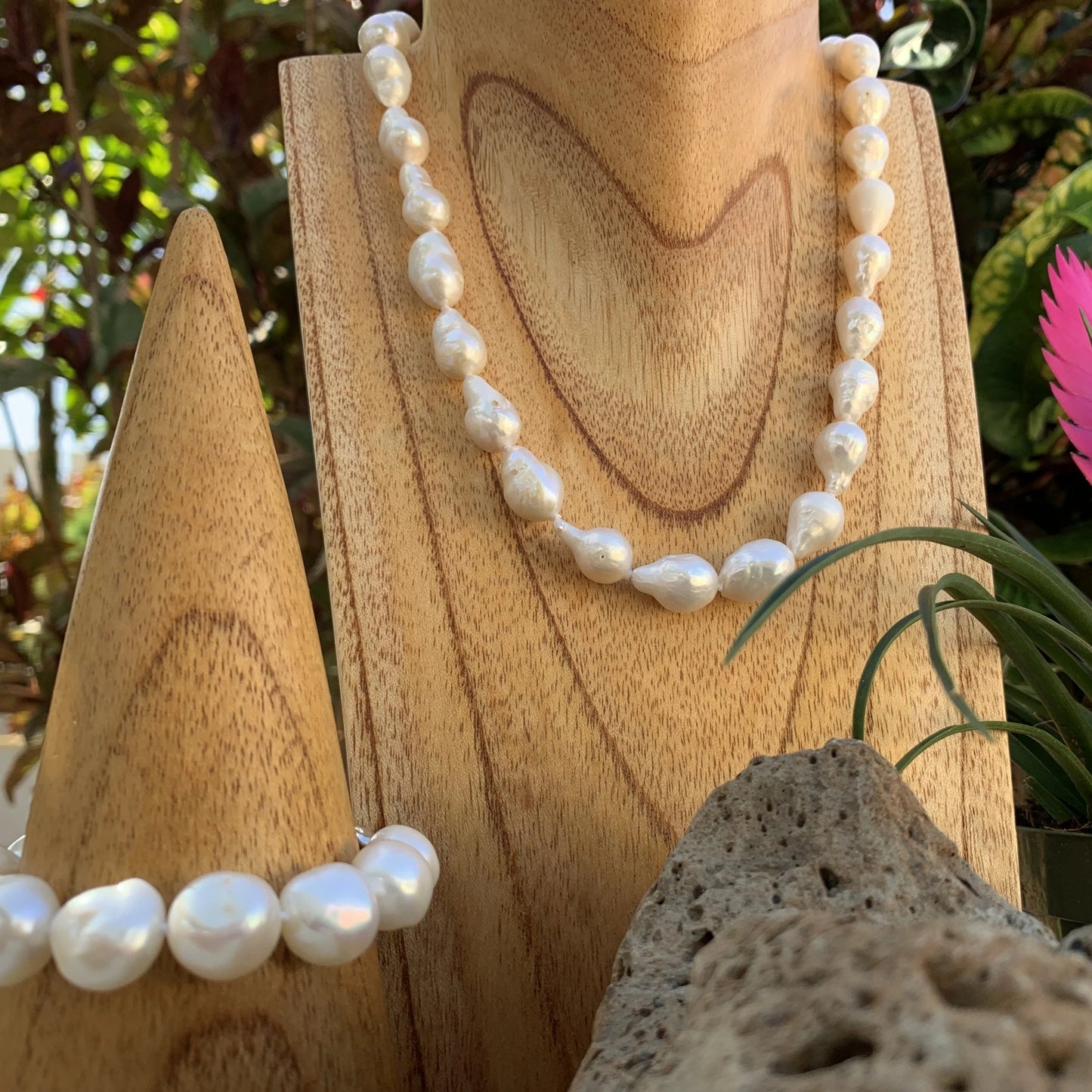 Baroque pearl necklace shown in white next to bracelet.