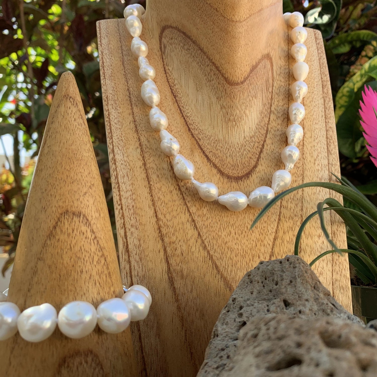 Baroque pearl necklace shown in white next to bracelet.