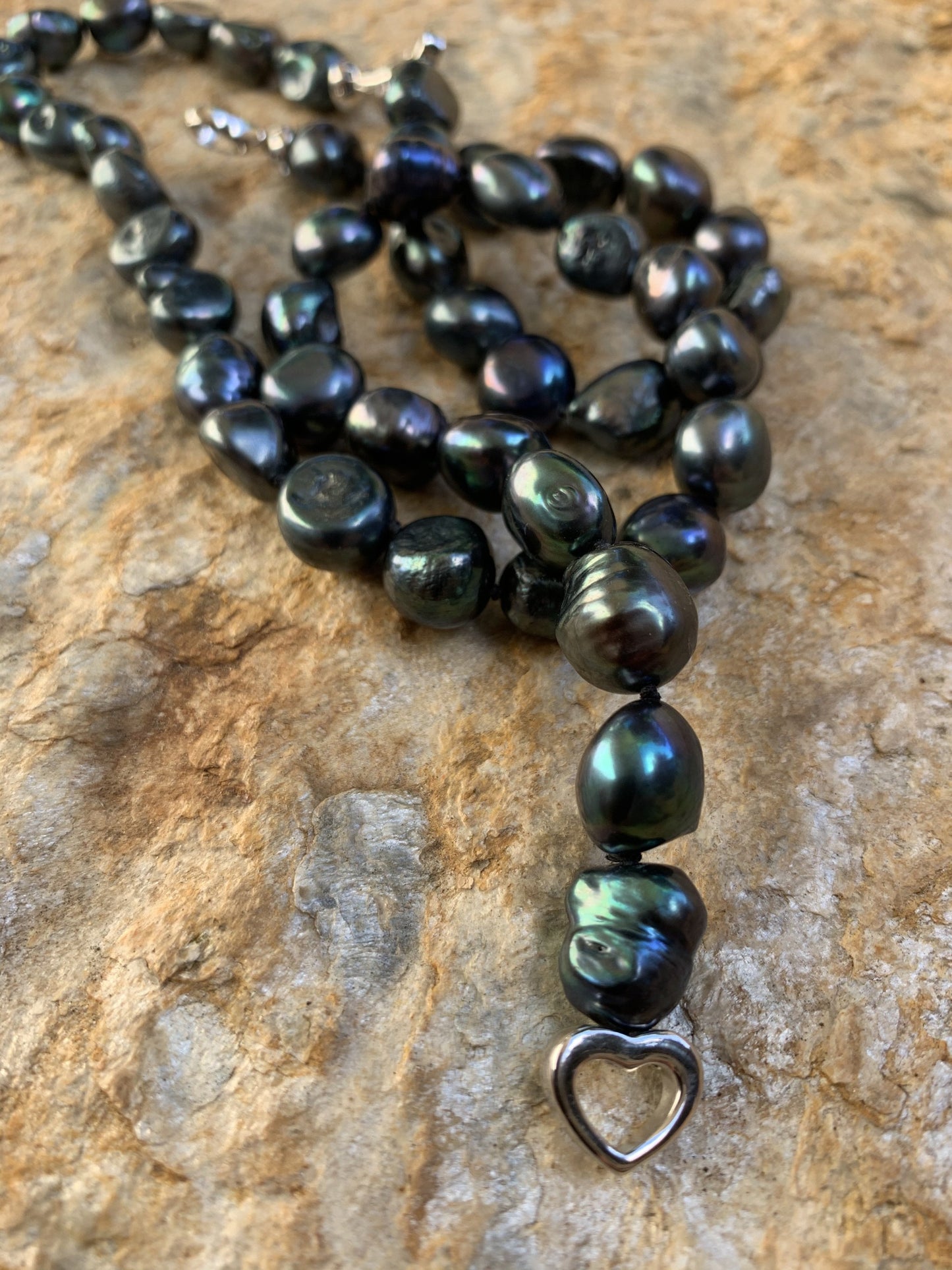 Baroque pearl necklace shown in black with heart clasp.