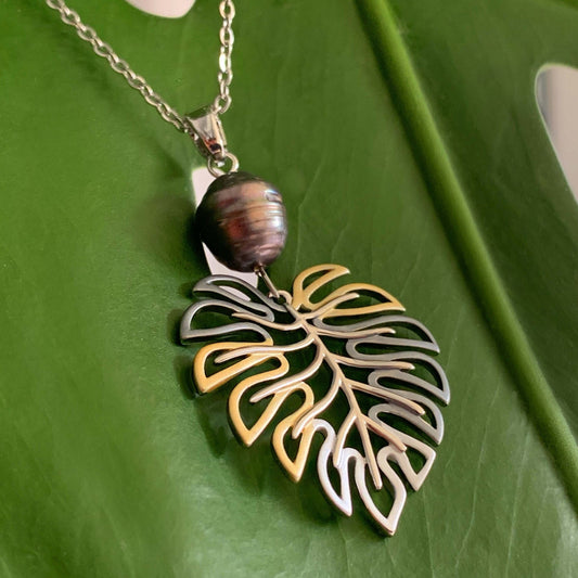 Monstera pearl pendant shown with black pearl.