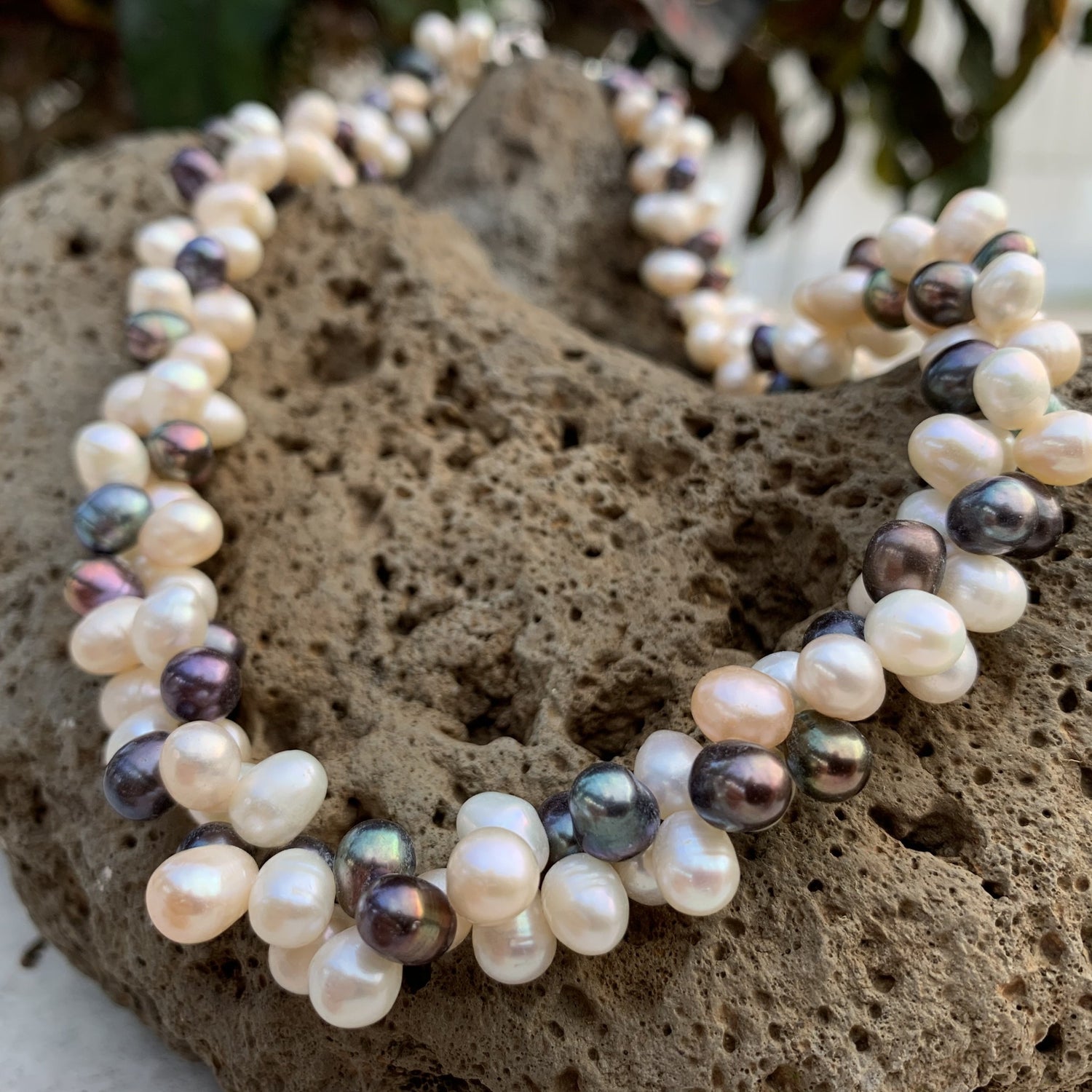 Cluster pearl necklace in mixed colors with black and white pearls.