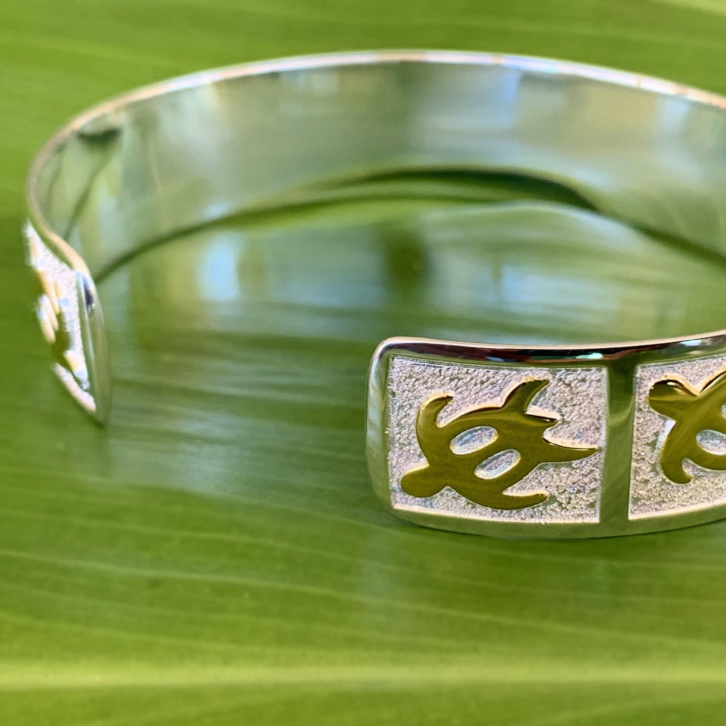 Close up of petroglyph honu cuff showing the back and how it is open and adjusts.