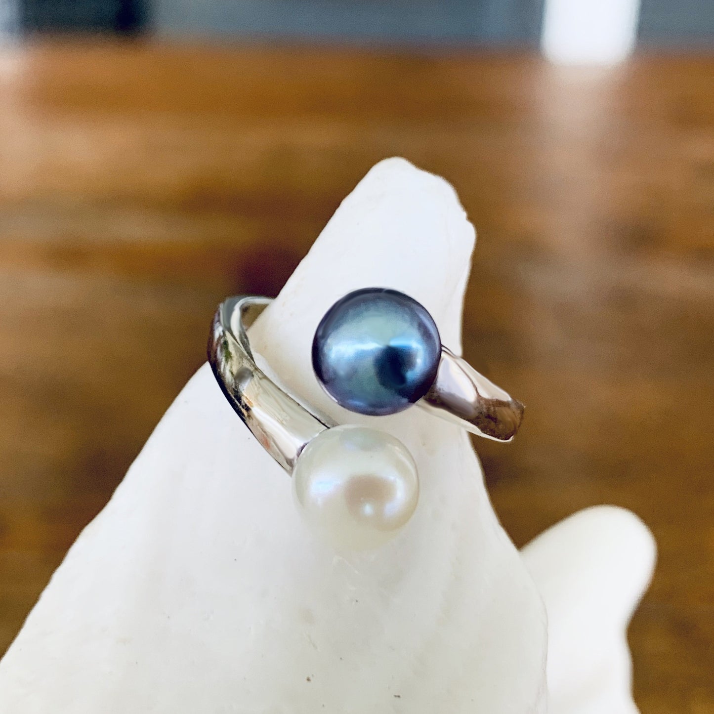 Freshwater pearl adjustable ring close up showing white and black pearls.